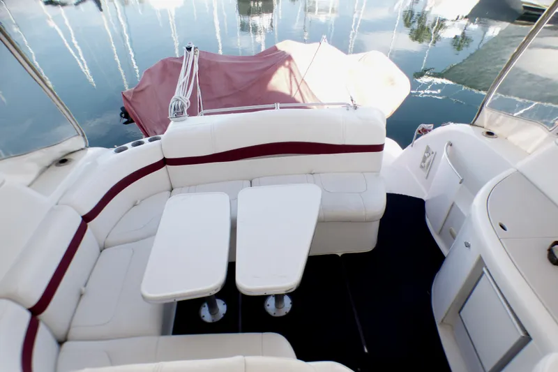 Slide: The Image of 2003 Formula 37 PC yacht interior with white seating and tables, docked on calm water. - 12