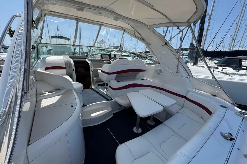 Slide: The Image of 2003 Formula 37 Performance Cruiser interior with white seating and table, docked at marina. - 15