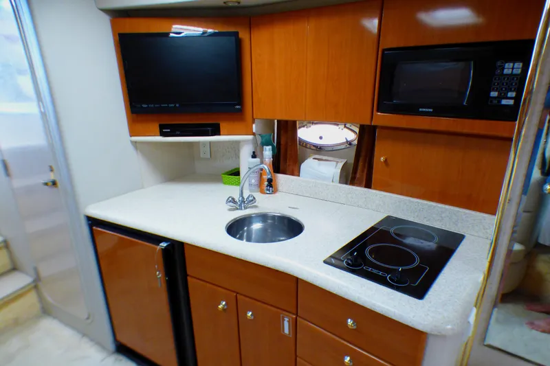 Slide: The Image of 2003 Formula 37 PC yacht kitchen with sink, stove, microwave, and TV. - 27
