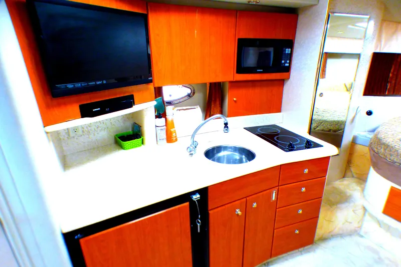 Slide: The Image of 2003 Formula 37 PC yacht kitchen with sink, stove, microwave, and TV. - 28