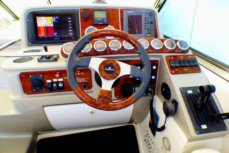 Slide: The Image of 2003 Formula 37 PC boat dashboard with wood accents and modern controls. - 40
