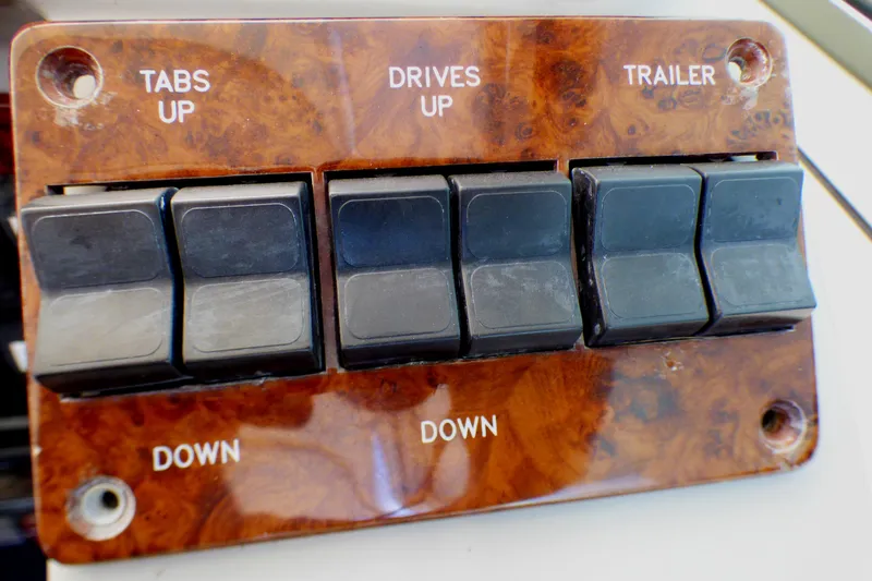 Slide: The Image of Control panel with switches for tabs, drives, and trailer on a 2003 Formula 37 PC boat. - 47