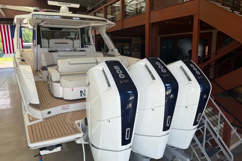Slide: The Image of 2024 Tiara Yachts 48 LS with triple Mercury 600 V12 engines in a showroom. - 56