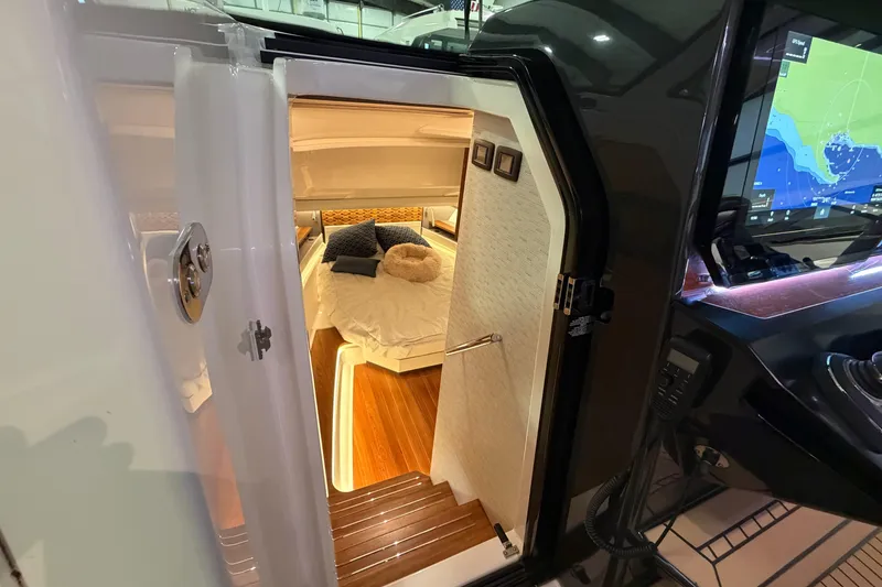 Slide: The Image of 2024 Tiara Yachts 48 LS cabin interior with luxurious bedding and modern navigation display. - 16