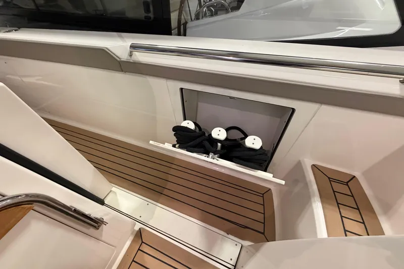 Slide: The Image of 2024 Tiara Yachts 48 LS interior with teak flooring and rope storage compartment. - 18