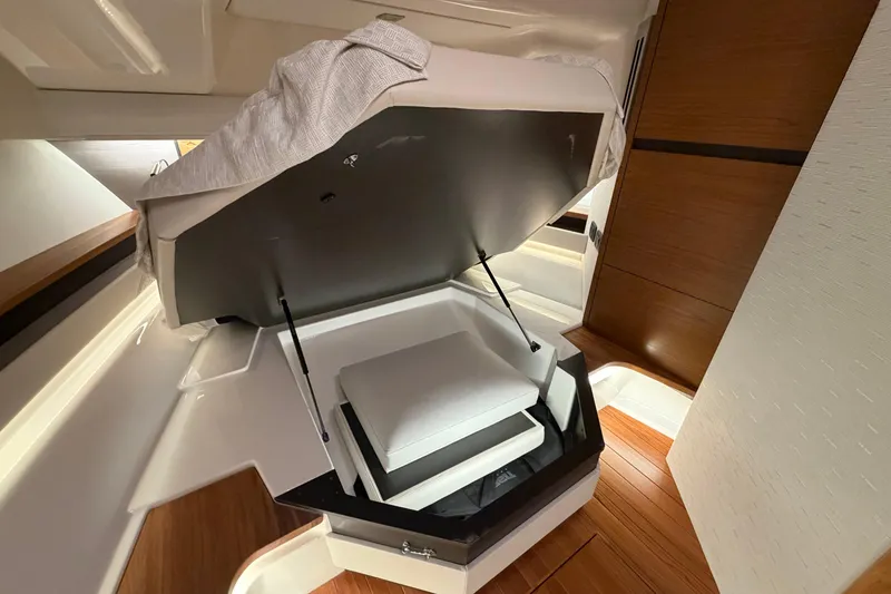Slide: The Image of 2024 Tiara Yachts 48 LS interior with open storage compartment and wooden flooring. - 20