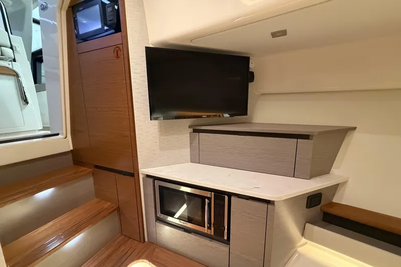 Slide: The Image of 2024 Tiara Yachts 48 LS interior with TV, microwave, and modern cabinetry. - 21