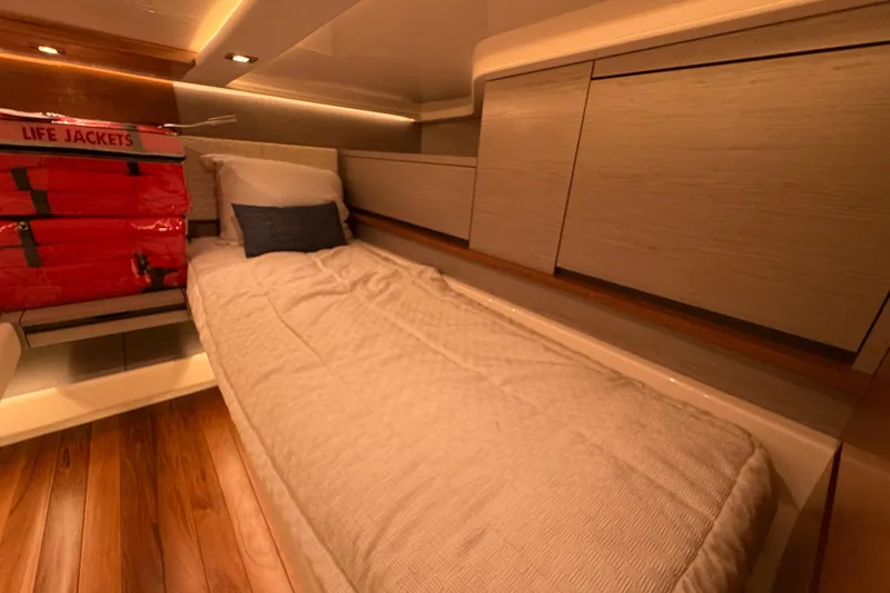 Slide: The Image of 2024 Tiara Yachts 48 LS cabin interior with bed and life jackets. - 30