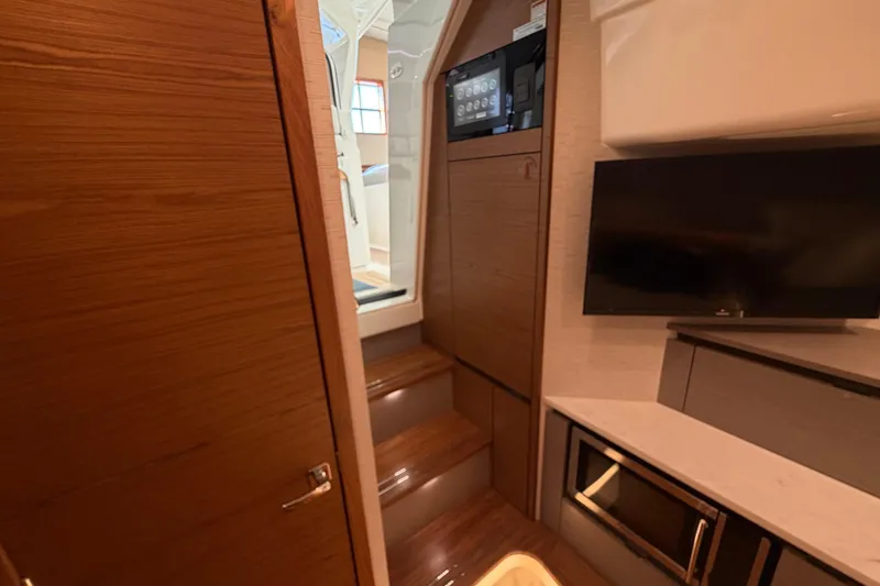 Slide: The Image of 2024 Tiara Yachts 48 LS interior with modern wood finish and built-in TV. - 27