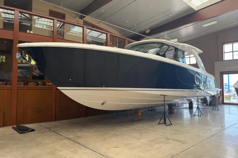 Slide: The Image of 2024 Tiara Yachts 48 LS luxury boat displayed indoors on stands. - 52