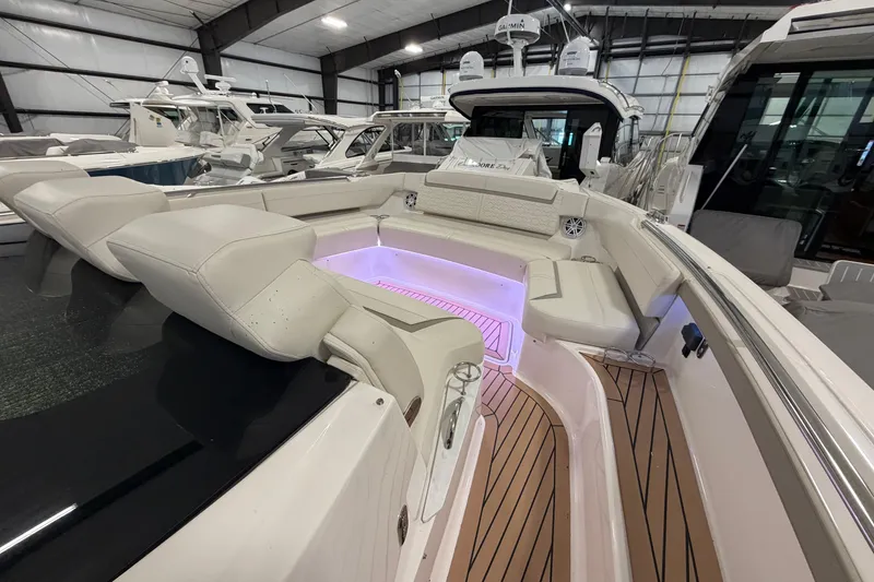 Slide: The Image of 2024 Tiara Yachts 48 LS luxury boat interior with ambient lighting and plush seating. - 5