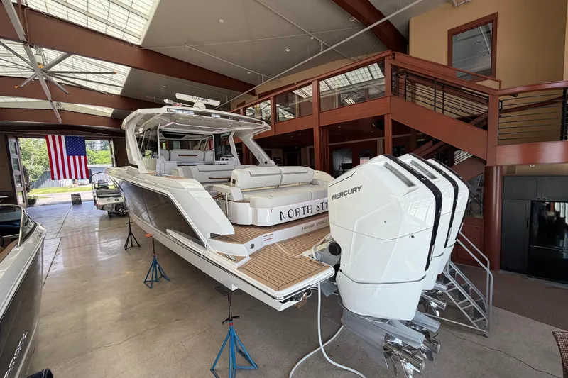 Slide: The Image of 2024 Tiara Yachts 48 LS in showroom with Mercury engines, American flag visible. - 54
