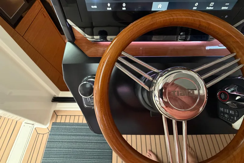 Slide: The Image of Steering wheel of 2024 Tiara Yachts 48 LS, showcasing elegant wood and chrome design. - 17