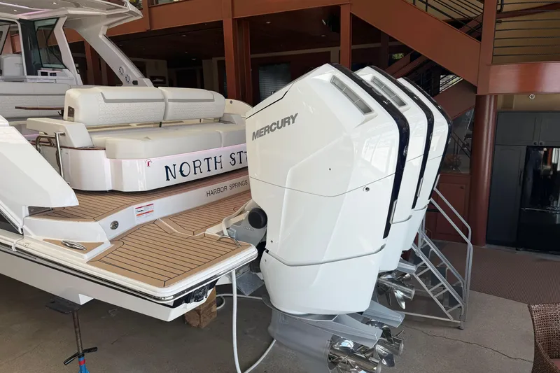 Slide: The Image of 2024 Tiara Yachts 48 LS with triple Mercury outboard engines, docked indoors. - 55