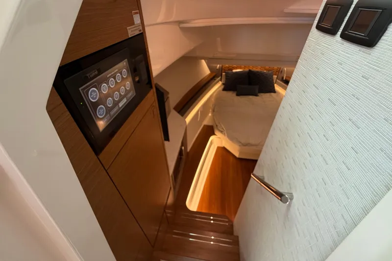 Slide: The Image of 2024 Tiara Yachts 48 LS interior cabin with modern control panel and cozy bed. - 19