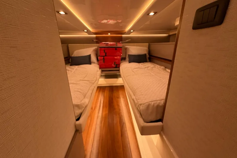 Slide: The Image of Luxurious cabin interior of 2024 Tiara Yachts 48 LS with twin beds and ambient lighting. - 28