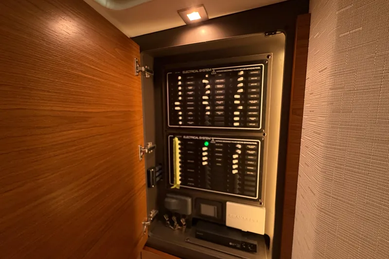 Slide: The Image of Electrical panel inside 2024 Tiara Yachts 48 LS, showcasing circuit breakers and controls. - 20
