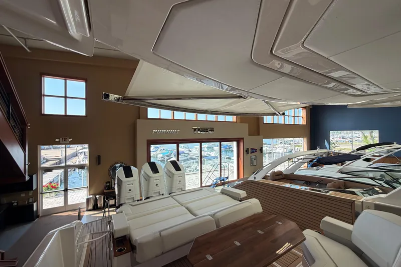 Slide: The Image of 2024 Tiara Yachts 48 LS interior view in a showroom with marina backdrop. - 50