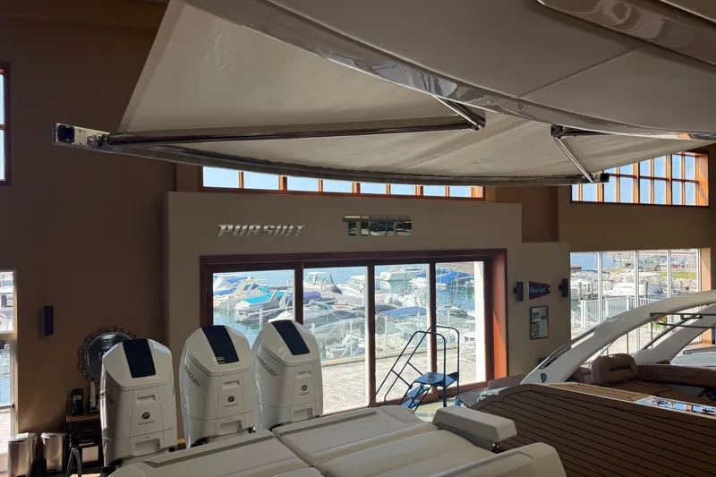 Slide: The Image of 2024 Tiara Yachts 48 LS displayed indoors with outboard engines and marina view. - 49