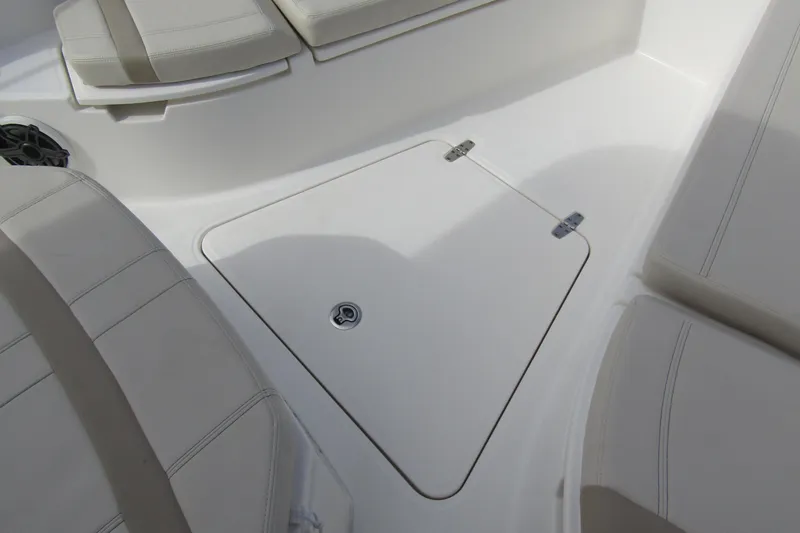 Slide: The Image of 2023 Boston Whaler 280 Dauntless boat interior with cushioned seating and storage hatch. - 17