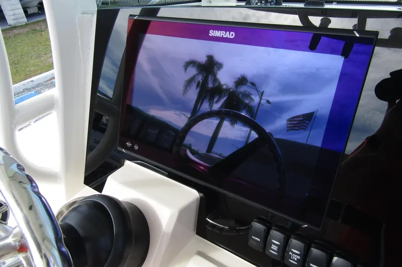 Slide: The Image of Simrad display on 2023 Boston Whaler 280 Dauntless, showing palm trees and American flag reflection. - 23
