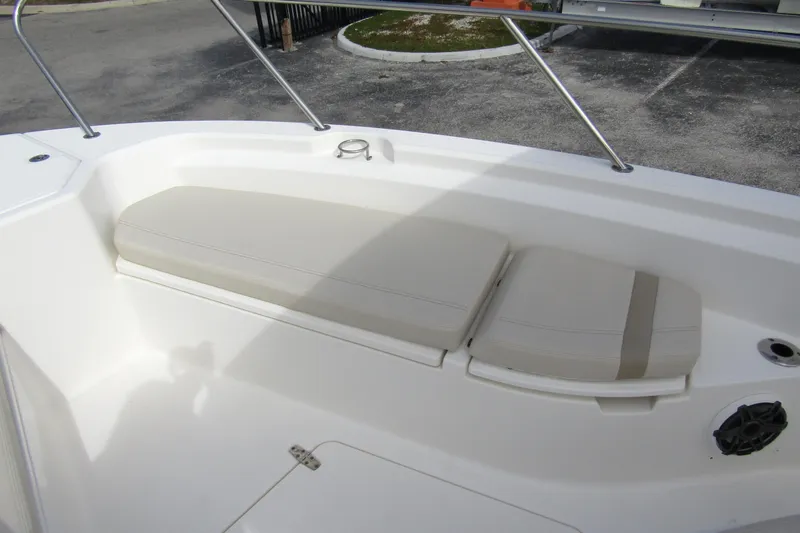 Slide: The Image of 2023 Boston Whaler 280 Dauntless boat seating area with cushioned bench and stainless steel railing. - 9