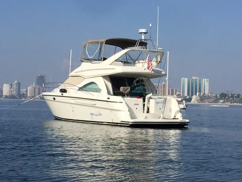 The Image of 1997 Maxum 4600 SCB yacht on calm water with city skyline in background. - 0