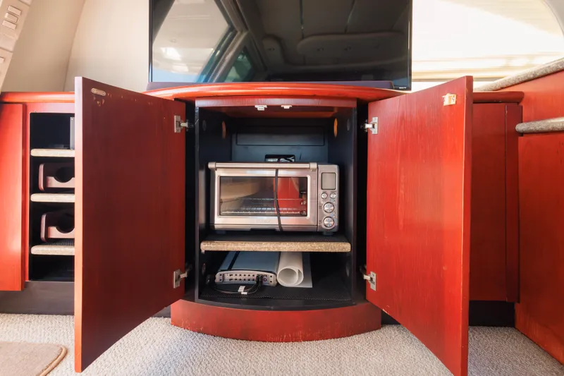 Slide: The Image of 1997 Maxum 4600 SCB yacht interior with open cabinet revealing a toaster oven. - 11