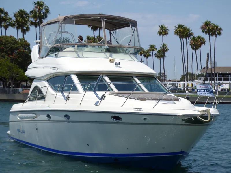 Slide: The Image of 1997 Maxum 4600 SCB yacht on water, palm trees in background, for sale sign visible. - 2