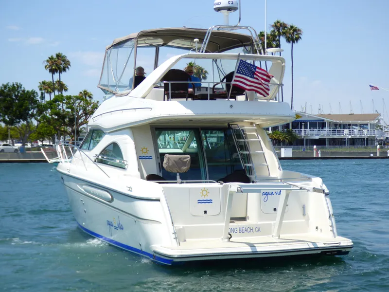 Slide: The Image of 1997 Maxum 4600 SCB yacht cruising in a marina with American flag. - 3