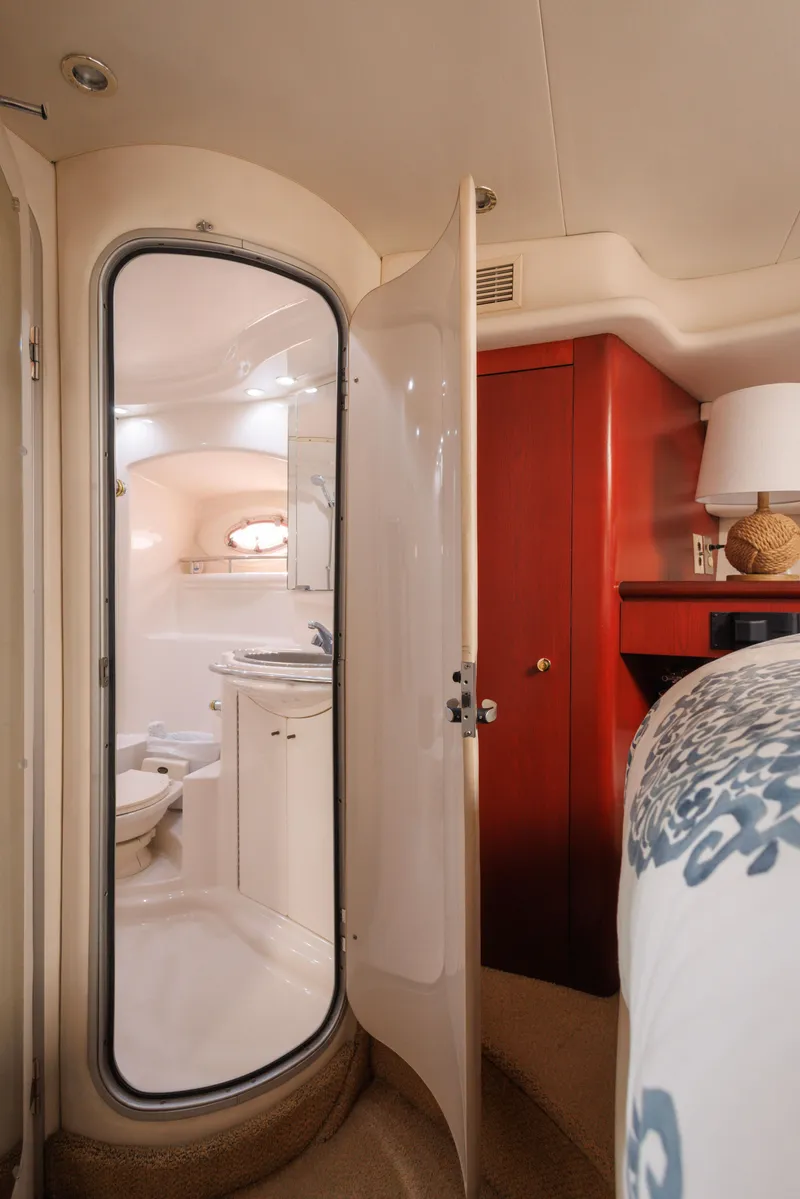 Slide: The Image of 1997 Maxum 4600 SCB yacht interior with bathroom, red cabinet, and bed. - 34