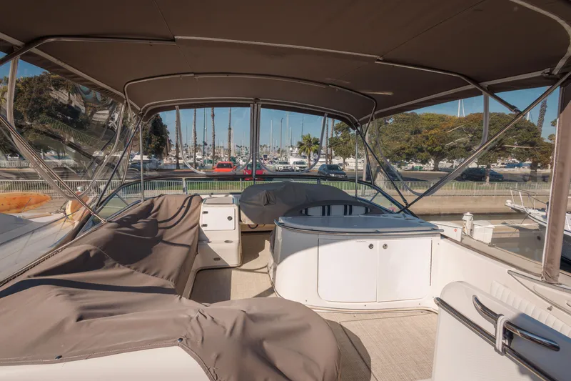 Slide: The Image of 1997 Maxum 4600 SCB yacht interior with covered seating and marina view. - 44