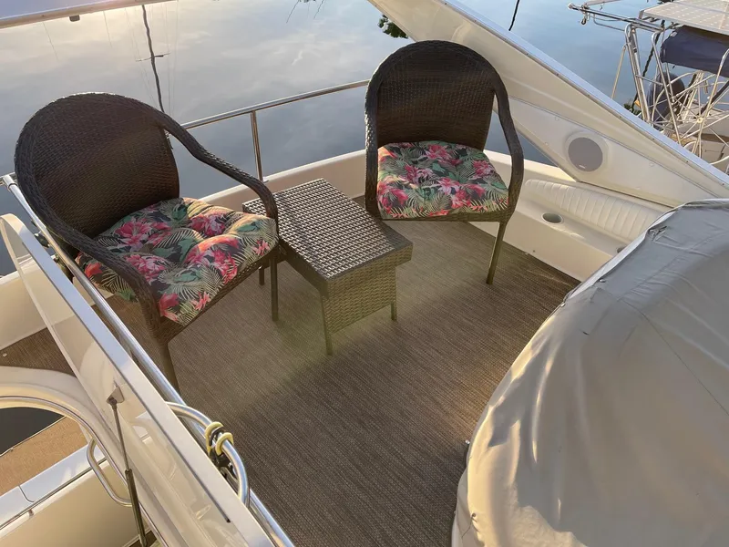 Slide: The Image of Outdoor seating area on 1997 Maxum 4600 SCB yacht with wicker chairs and floral cushions. - 45