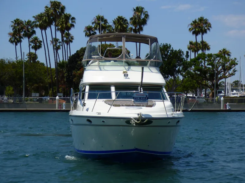 Slide: The Image of 1997 Maxum 4600 SCB yacht on water, surrounded by palm trees, for sale. - 5