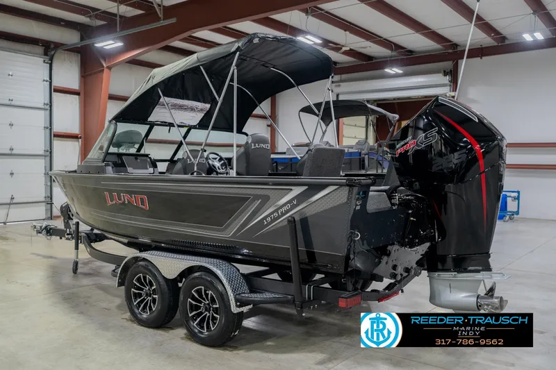 Slide: The Image of 2026 Lund 1975 Pro-V Sport boat in showroom, featuring sleek design and powerful engine. - 11