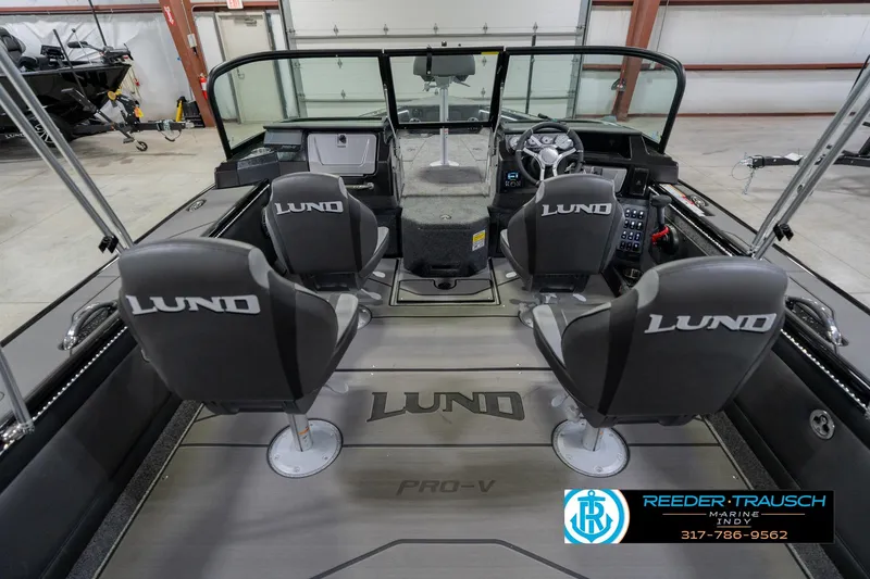 Slide: The Image of 2026 Lund 1975 Pro-V Sport boat interior with four seats and steering console in showroom. - 17