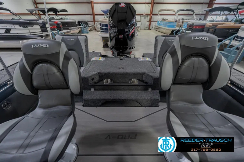 Slide: The Image of 2026 Lund 1975 Pro-V Sport boat interior with seating and motor, in showroom. - 22