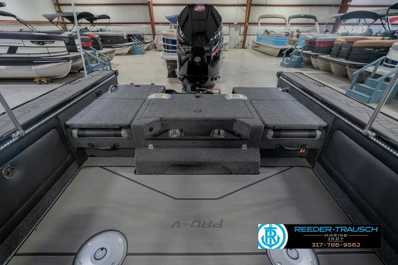 Slide: The Image of 2026 Lund 1975 Pro-V Sport boat interior with motor, in a showroom setting. - 24