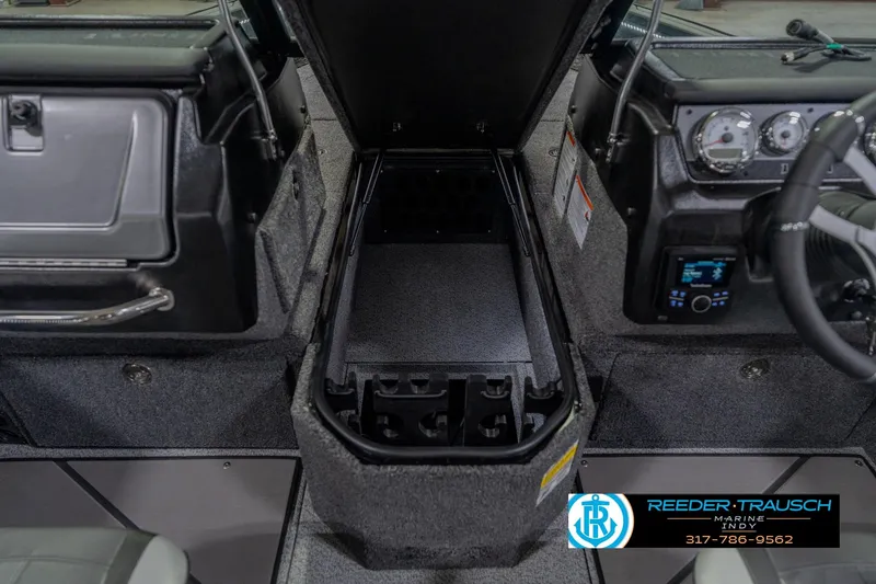 Slide: The Image of 2026 Lund 1975 Pro-V Sport boat interior with open storage compartment and dashboard controls. - 31