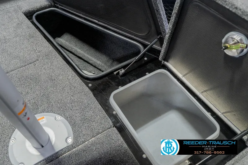 Slide: The Image of 2026 Lund 1975 Pro-V Sport boat storage compartments with carpeted interior and secure latches. - 33