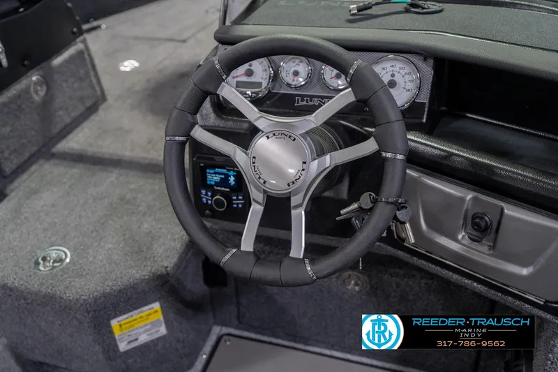 Slide: The Image of Steering wheel of 2026 Lund 1975 Pro-V Sport boat with dashboard controls. - 34