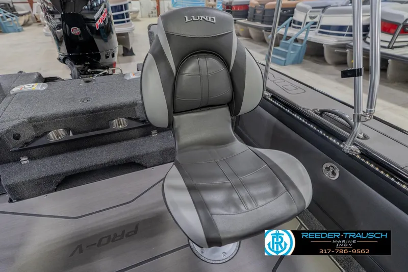 Slide: The Image of 2026 Lund 1975 Pro-V Sport boat interior with gray seating and motor, Reeder-Trausch Marine logo. - 46