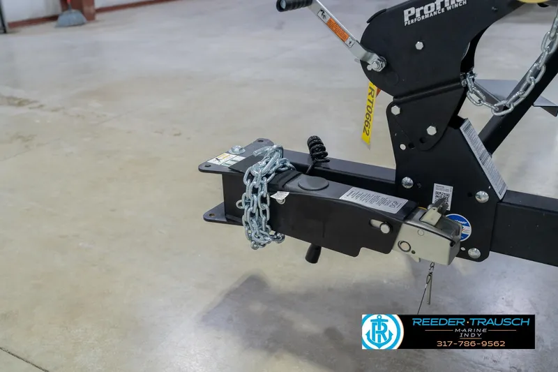 Slide: The Image of Trailer hitch with chain on Lund 1975 Pro-V Sport, 2026 model, in a garage setting. - 60