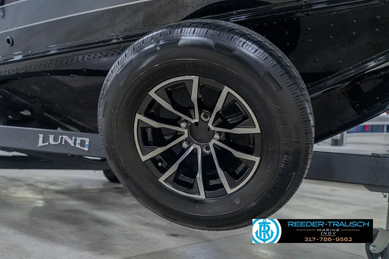 Slide: The Image of 2026 Lund 1975 Pro-V Sport trailer wheel, black alloy rim, Reeder-Trausch Marine logo. - 63