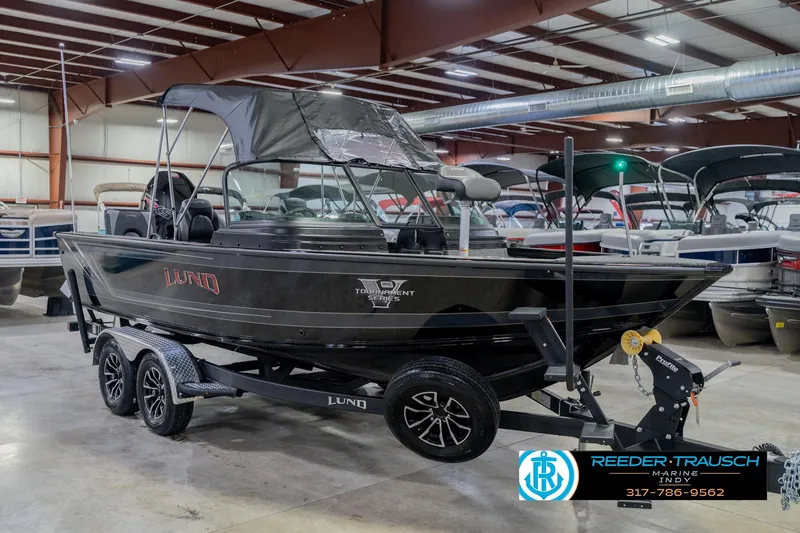 Slide: The Image of 2026 Lund 1975 Pro-V Sport boat in showroom, black exterior, on trailer. - 7