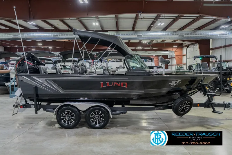 Slide: The Image of 2026 Lund 1975 Pro-V Sport boat in showroom, featuring sleek design and modern features. - 8