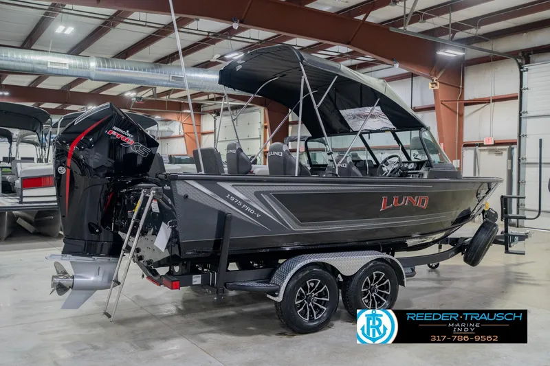 Slide: The Image of 2026 Lund 1975 Pro-V Sport boat in showroom, featuring sleek design and powerful engine. - 9