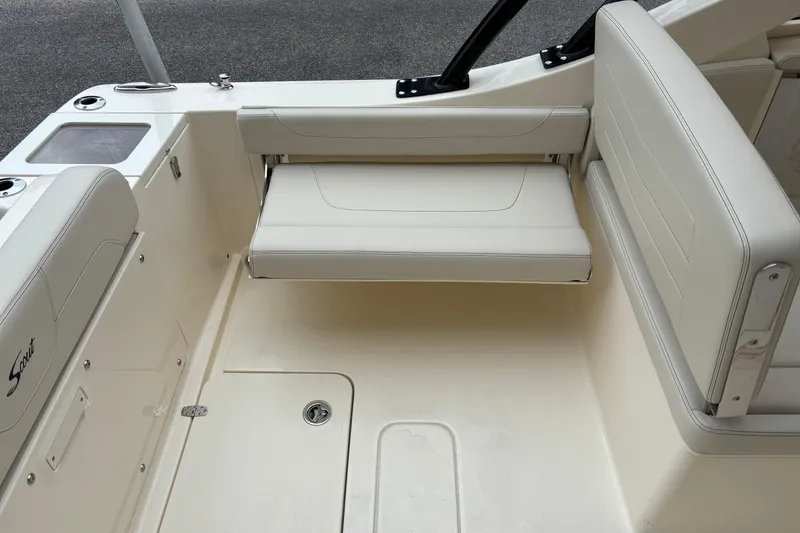 Slide: The Image of 2026 Scout 240 Dorado boat interior with beige seating and storage compartments. - 13