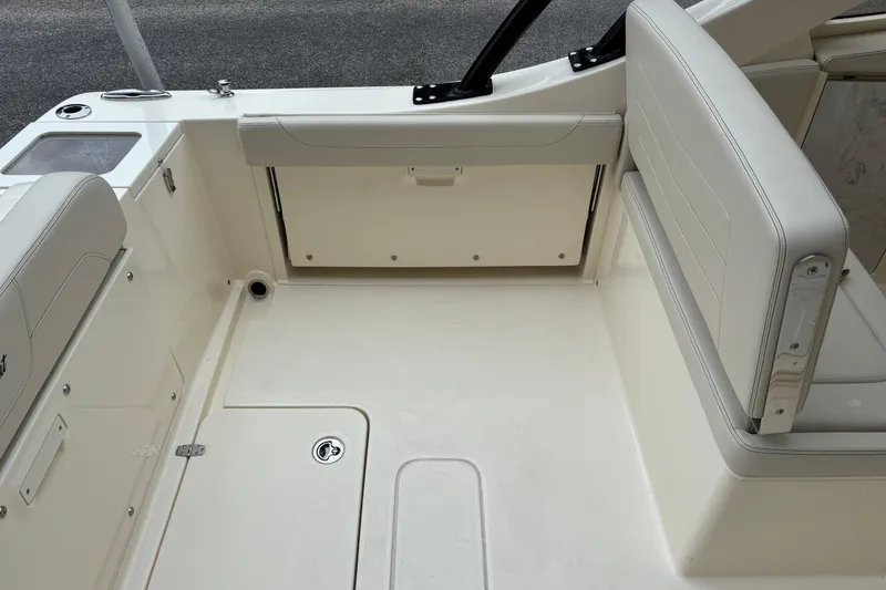 Slide: The Image of 2026 Scout 240 Dorado boat interior with beige seating and storage compartments. - 14