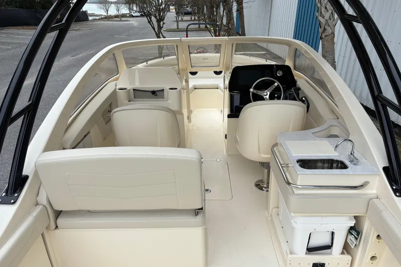 Slide: The Image of 2026 Scout 240 Dorado boat interior with seating, steering wheel, and sink. - 18